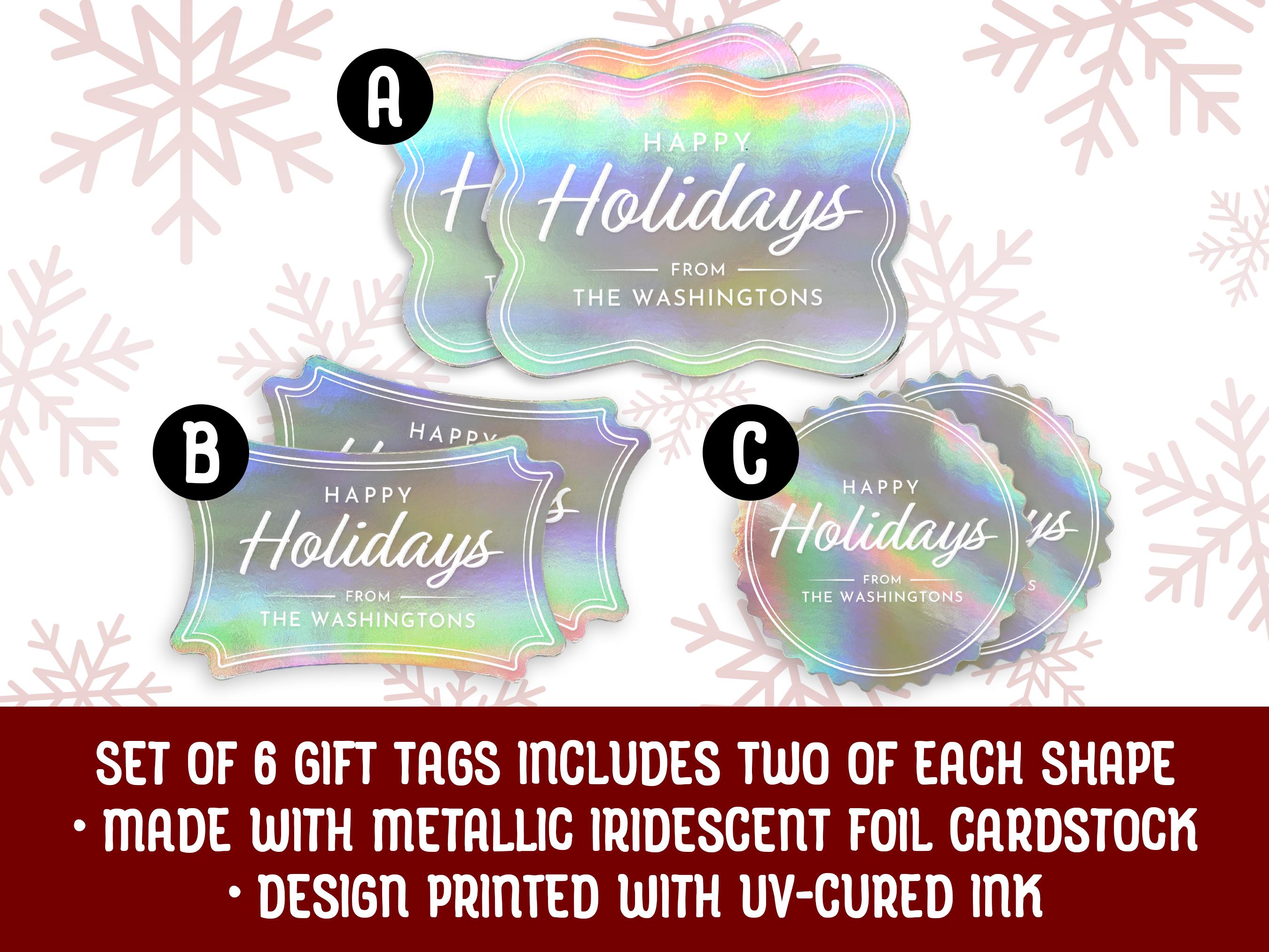Text reads, Set of 6. Three iridescent foil cardstock Happy Holiday gift tags are shown on a light blue surface surrounded by snowflakes.