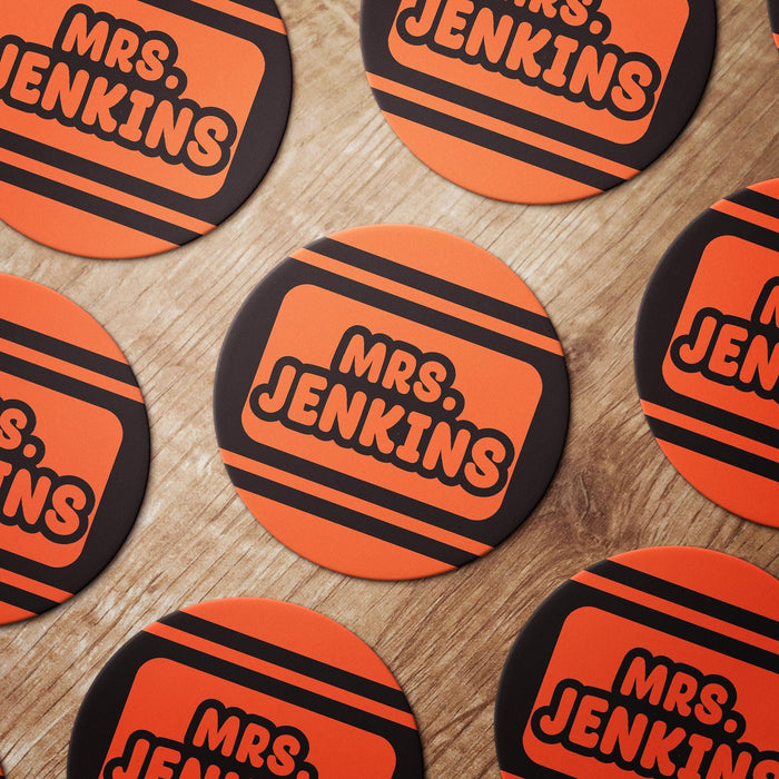 Multiple Crayola design coasters arranged together in orange color with custom names. Shows repeat design and ordering consistency.