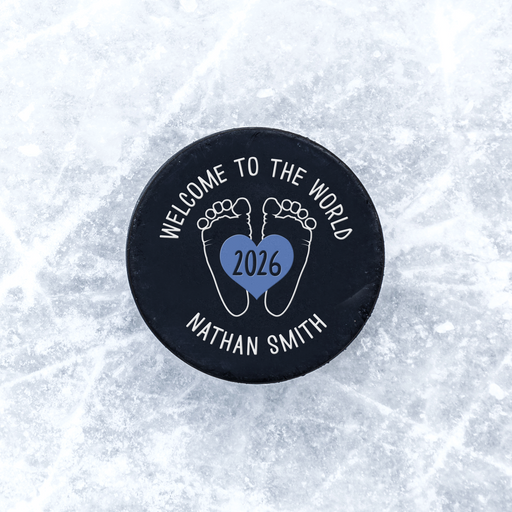 Personalized hockey puck with a UV printed baby feet birth announcement design displayed on an icy background.