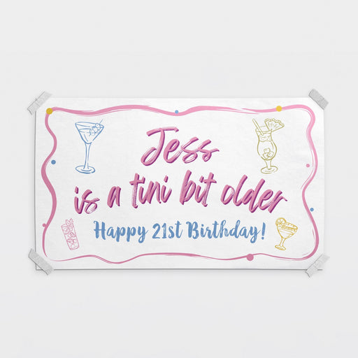 Personalized "Tini Bit Older" birthday banner featuring a custom name and birthday age with cocktail-themed artwork.