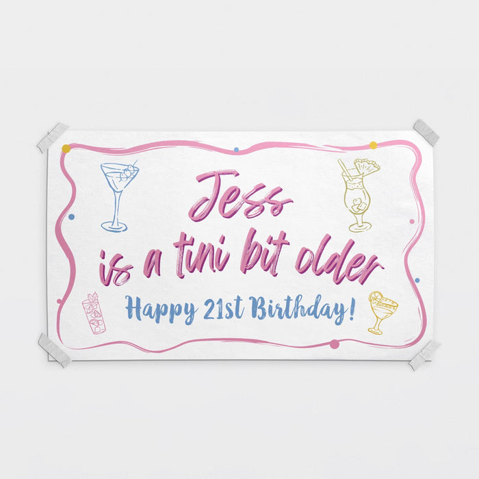 Personalized "Tini Bit Older" birthday banner featuring a custom name and birthday age with cocktail-themed artwork.