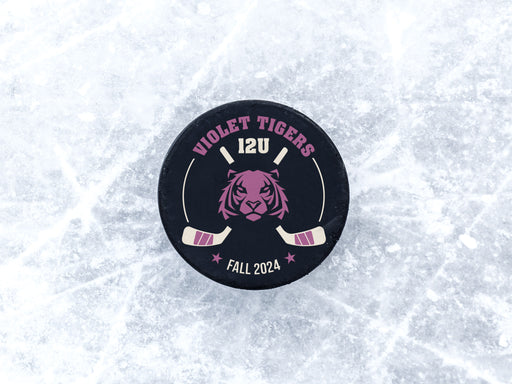 Hockey puck on ice rink with a purple tiger animal mascot design with the wordsViolet Tigers, 12U, Fall 2024