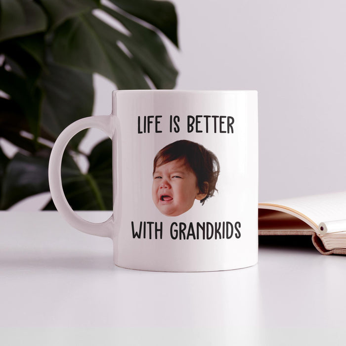 Custom photo mug for grandparents displayed on a table with “Life Is Better With Grandkids” design.