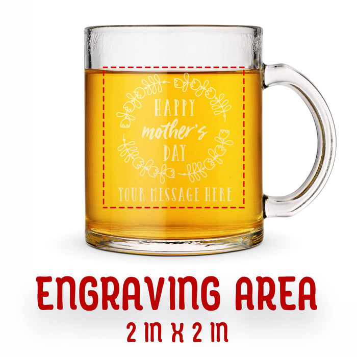 A glass mug with an engraved design on it. The mug is filled with tea, and there is text under the mug that reads "Engraving Area is 2 in x 2 in”