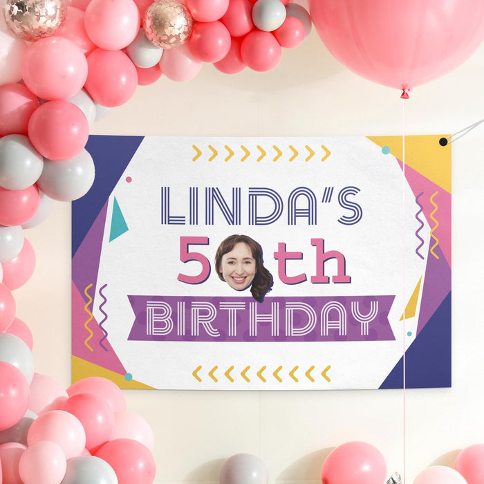 Personalized retro birthday banner displayed as a party backdrop with pink balloon decorations.