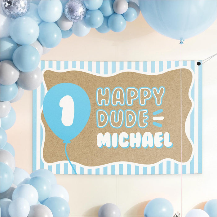 ONE Happy Dude birthday backdrop displayed with blue balloons and party décor for a boy’s first birthday celebration.