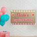 Berry first birthday banner displayed as party wall décor with colorful balloons and custom personalized name printed on butcher paper.