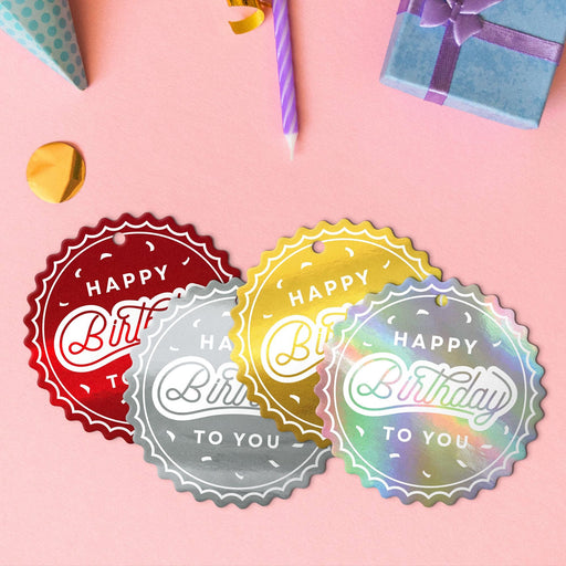 Four birthday round tags in metallic gold, metallic silver, glitter red, and glitter rainbow.