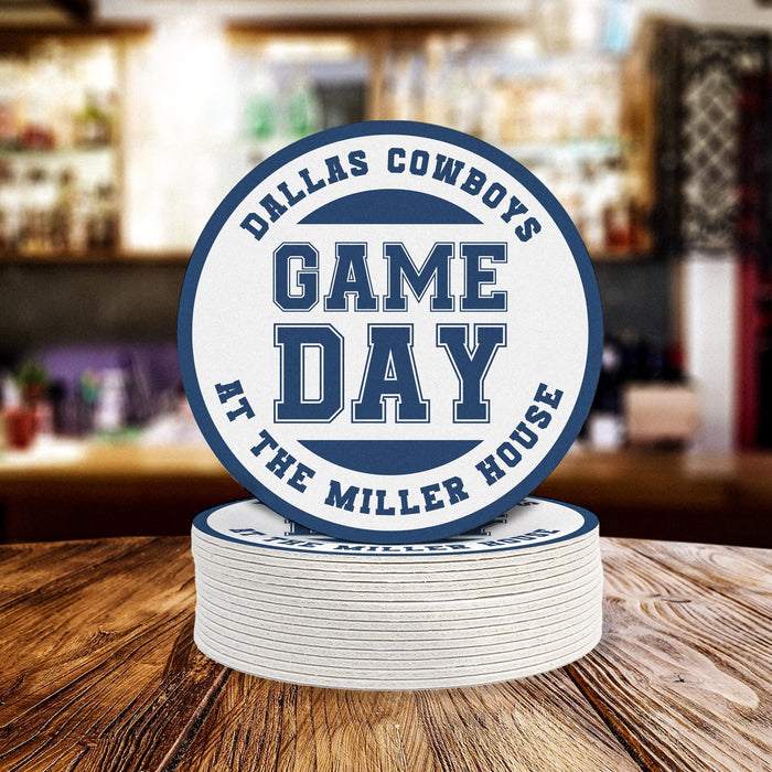 Stack of personalized Game Day paper coasters featuring bold varsity lettering, custom team wording, and a house or family name.