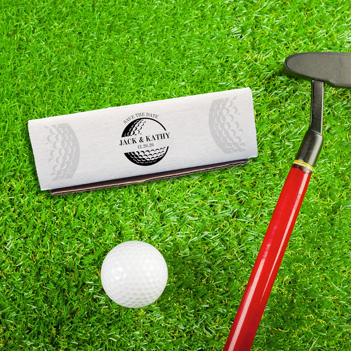 Golf-themed wedding gift box displayed on a putting green with a golf club and golf ball. Personalized for a golf-loving bride and groom.
