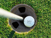 Titleist golf ball shown in a golf course hole.