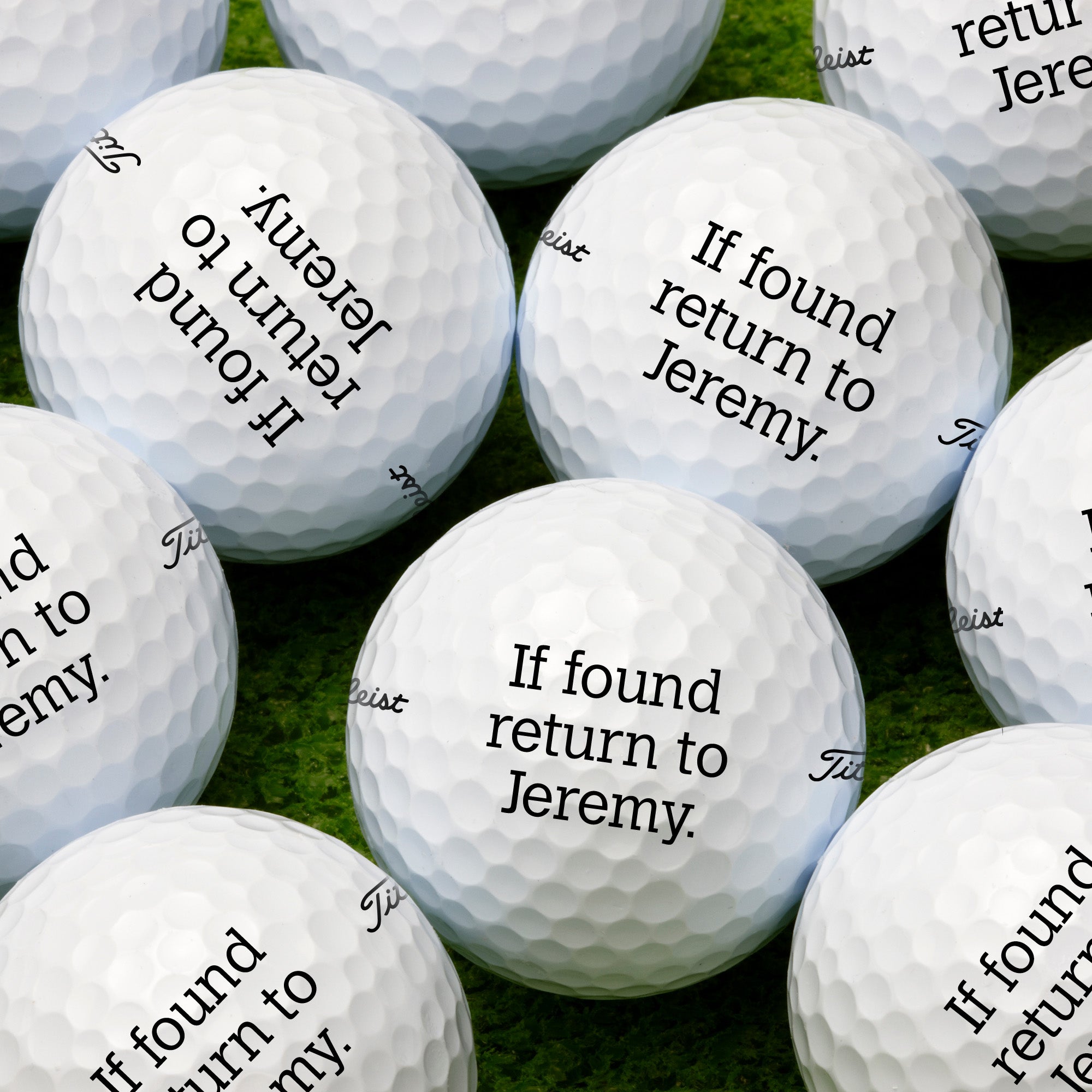 single white titles golf ball with your text here on it against a grass golf course background