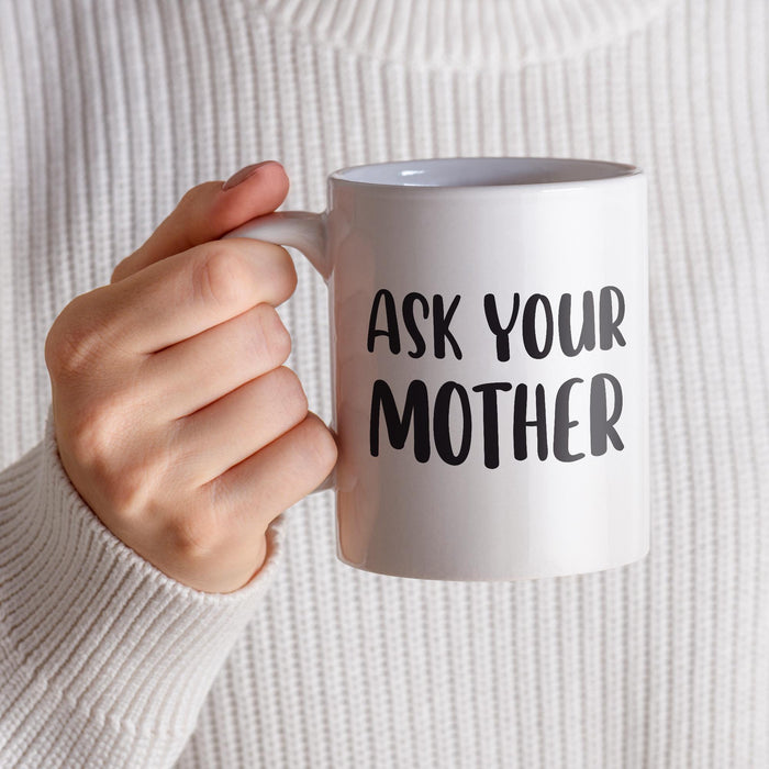 A person holding the “Ask Your Mother” mug while wearing a cozy neutral sweater. The warm close-up creates a comfortable everyday coffee moment.