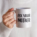A person holding the “Ask Your Mother” mug while wearing a cozy neutral sweater. The warm close-up creates a comfortable everyday coffee moment.