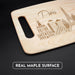 Angled view of the Paris maple cutting board with handle, engraved skyline, and natural wood grain.