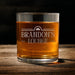 Front-facing product image of the whiskey glass on a wooden table with the “Brandon’s Lounge” design fully visible. This simple presentation helps customers clearly see the personalization layout and engraving style.