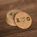 Round cork coasters featuring a hand-drawn heart monogram and personalized initials on a wood table.