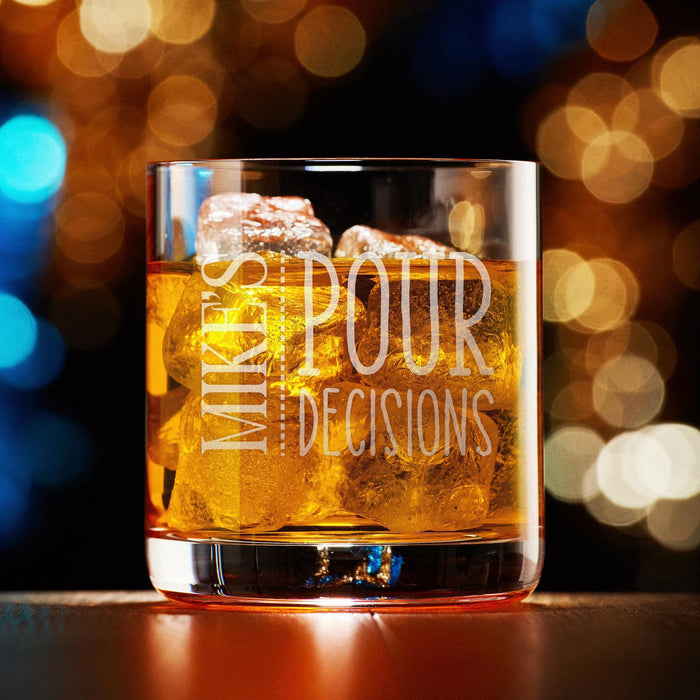 Elegant product photo of a personalized whiskey glass filled with whiskey and ice against a soft bokeh background, featuring the “Mike’s Pour Decisions” engraved design. The warm lighting highlights the playful custom engraving and premium glass quality.