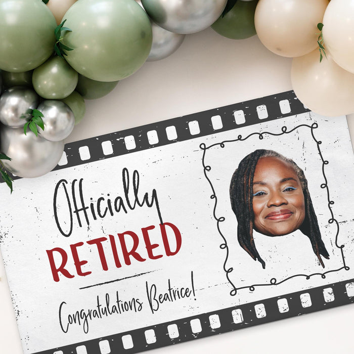 Close-up view of the personalized retirement banner showcasing the custom photo area, retiree name, and vintage filmstrip-inspired design details.