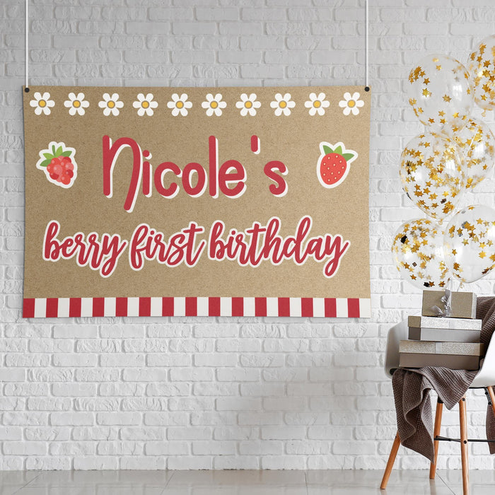 Close-up view of the personalized strawberry themed first birthday banner with berry graphics, daisy border, and bold custom lettering.
