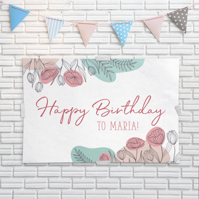 Personalized floral banner displayed on a white brick wall with decorative party bunting.
