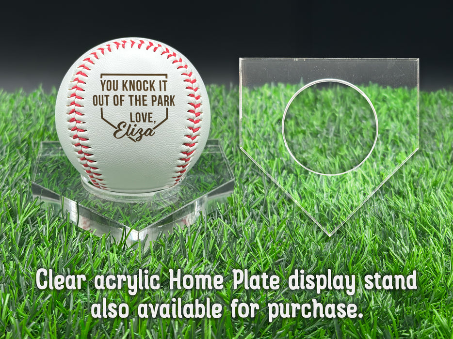 A personalized baseball with red stitching is placed on a clear acrylic stand, accompanied by a text overlay that reads Clear acrylic Home Plate display stand also available for purchase.