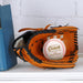 A baseball glove with a personalized baseball inside it, placed on a white surface next to a blue book.