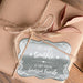 Personalized “Let Love Sparkle” wedding gift tag attached to kraft paper wrapping using natural twine. The metallic silver foil finish and decorative border create an elegant keepsake-style presentation.