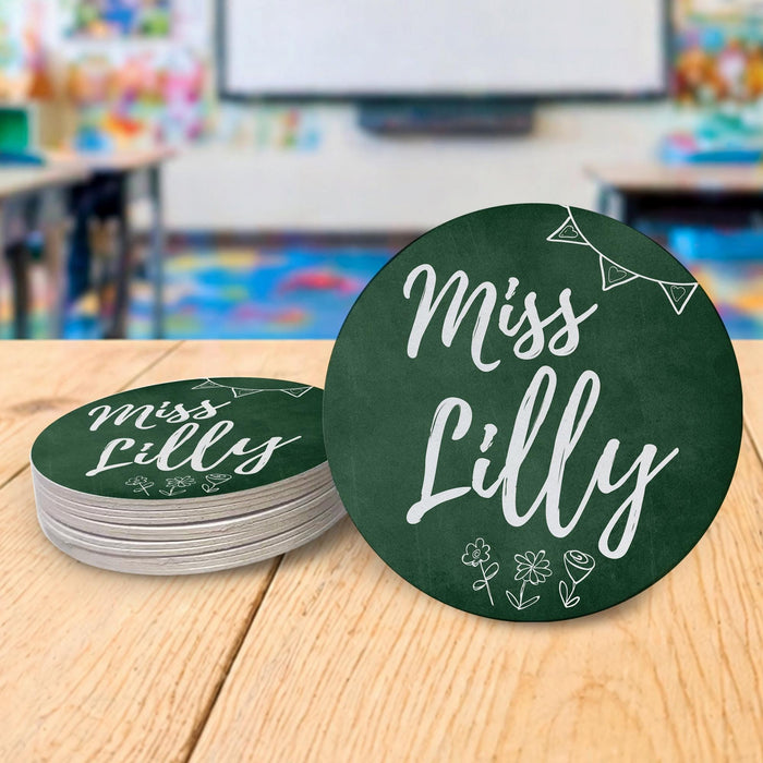 Personalized teacher coasters displayed in a classroom setting. Demonstrates real-life teacher desk use.