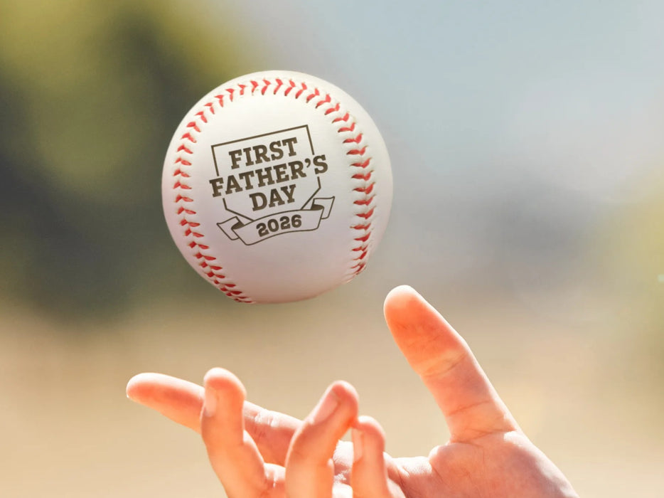 Person throws baseball into the air. Baseball has First Father's Day design engraved on it.