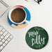 Lifestyle image of personalized teacher coasters on a desk with coffee and workspace items. Shows real-life classroom or home use.