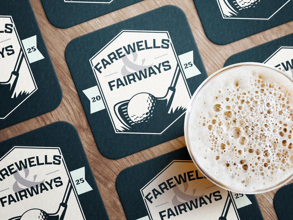 Custom square pulpboard coasters are shown laid out on a wooden surface. A beer mug is shown on top of a few of the coasters. The coaster features design with an illustration of a golf ball and with club behind it and custom text.
