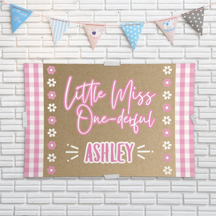 Little Miss ONE-derful birthday backdrop displayed against a white brick wall showing the printed butcher paper material and bright pink design.