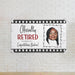 Personalized retirement banner mounted on a white brick wall. Features a custom photo, retiree name, and Officially Retired design printed on quality white paper.