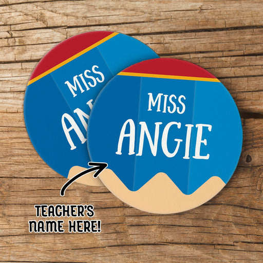 Personalized teacher coasters featuring pencil design with custom teacher name displayed on a wood background. Ideal for classroom gift use.