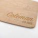 Close-up of a personalized maple cutting board engraved with Coleman and EST. 2026.