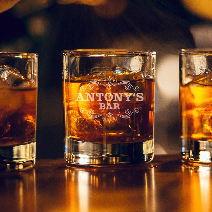 Warm bar-style lifestyle image of the personalized whiskey glass with glowing ambient lights in the background. The “Antony’s Bar” engraving is highlighted beautifully, giving the glass a premium lounge-inspired atmosphere.