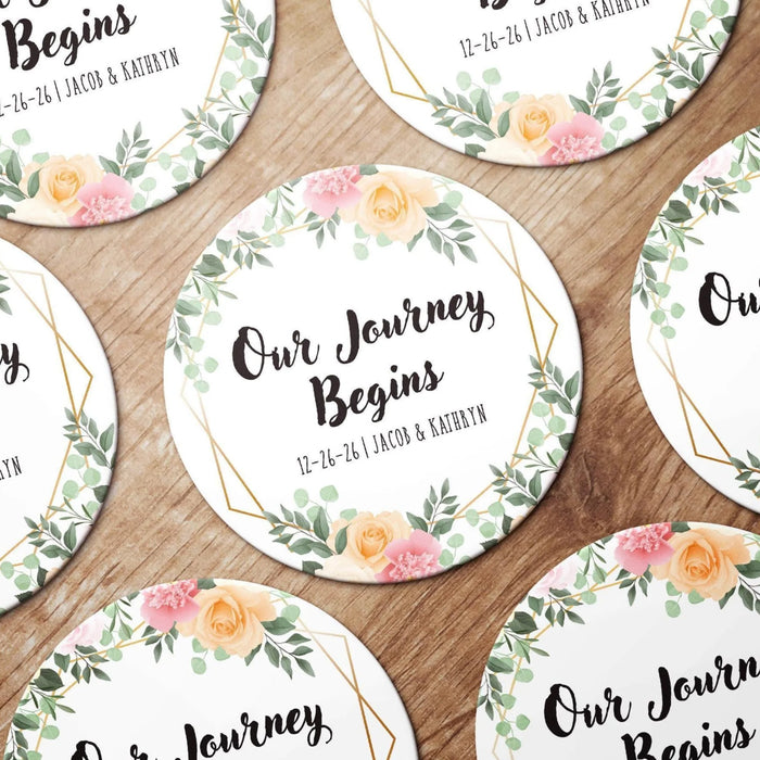 Personalized floral Save the Date coasters shown in a wedding favor arrangement. Features a floral wreath design with custom names and wedding date.