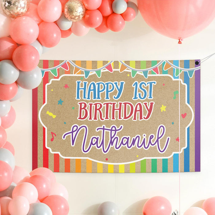 Rainbow themed first birthday banner displayed with colorful party balloons and decorations for a bright birthday celebration.