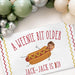 Personalized hot dog birthday banner displayed beneath a balloon garland featuring a custom name, age, and face cutout.