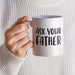 A person holding a white ceramic mug with the phrase “Ask Your Father” printed in bold black lettering. The cozy neutral sweater and soft background create a warm everyday coffee moment.