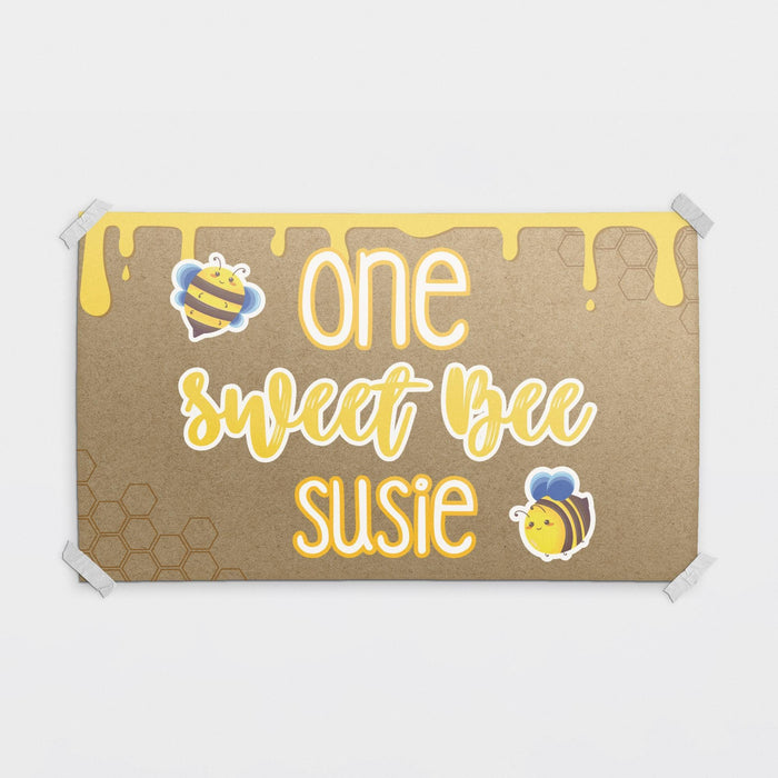 Personalized One Sweet Bee birthday banner printed on brown butcher paper with honey drip graphics, cute bee illustrations, and custom name personalization.