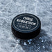 Personalized black hockey puck with a white UV printed birth announcement design featuring the baby’s name, weight, length, and birth date in a round layout.