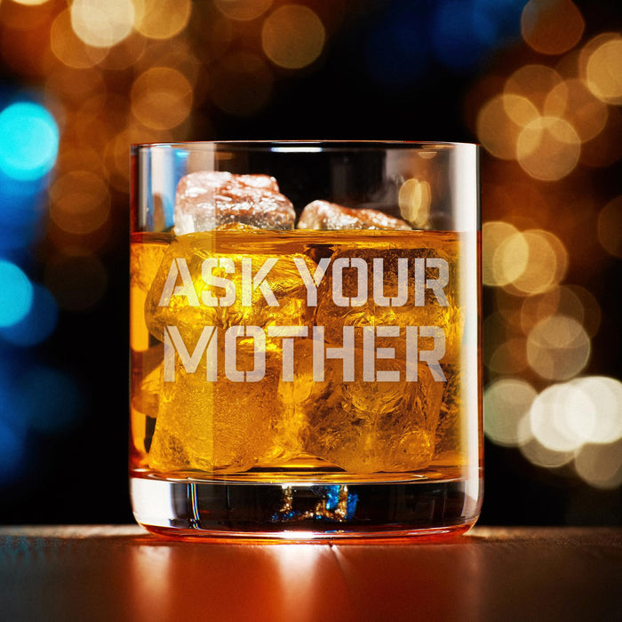 Elegant product photo of the engraved whiskey glass against a warm bokeh background. The humorous phrase is centered and easy to read.