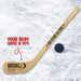 Personalized mini wooden hockey stick featuring baby name and birth details in a bold layout with a hockey puck graphic, shown on an ice background with a real puck.