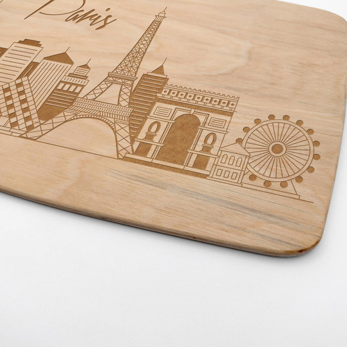 Close-up of the laser engraved Paris skyline featuring the Eiffel Tower and other city landmarks on maple wood.