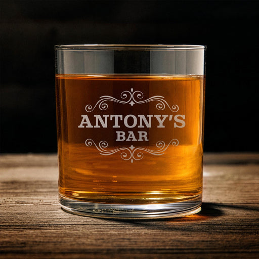 Front-facing product image of a personalized whiskey glass on a wooden table featuring the “Antony’s Bar” engraved design. The rich whiskey color and clean presentation highlight the elegant home bar style and premium engraving.