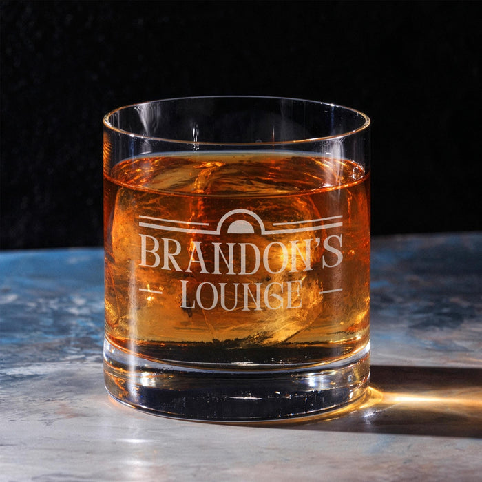 Clean hero-style image of a personalized whiskey glass on a marble surface featuring the “Brandon’s Lounge” engraved design. The rich whiskey color and dramatic lighting highlight the premium quality and elegant custom engraving.
