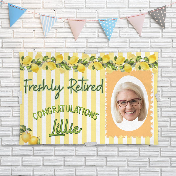 Retirement banner mounted on a white brick wall featuring lemon accents, custom photo, and personalized retiree name. Ideal for retirement party décor and photos.