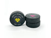 three stacked hockey pucks with printed 1st fathers day designs in the color yellow and pink with the names Alicia & Emma